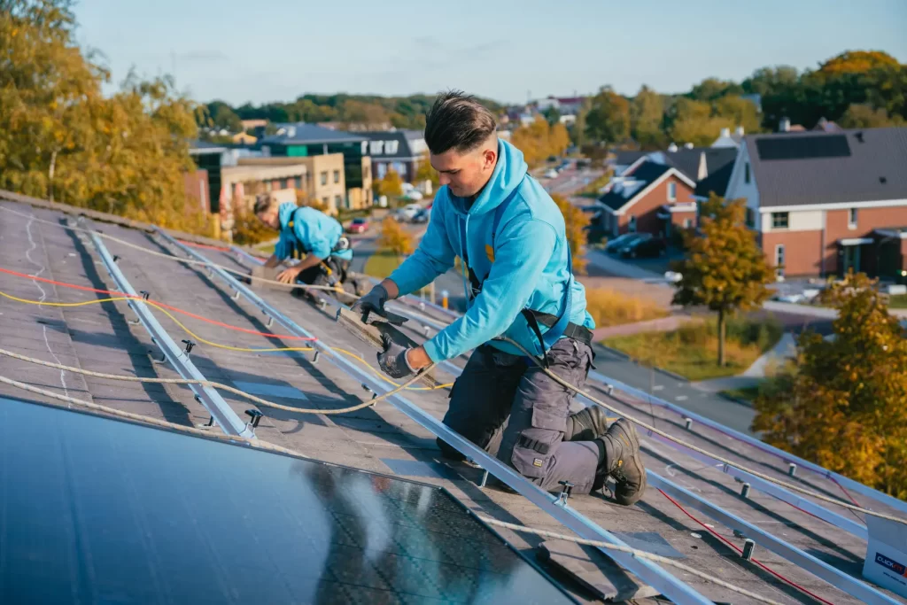 Monteurs leggen zonnepanelen op een schuin dak