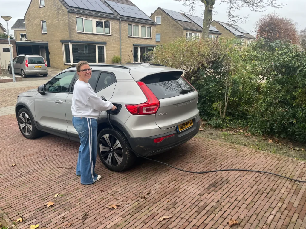 Klant laadt een elektrische auto op de eigen oprit